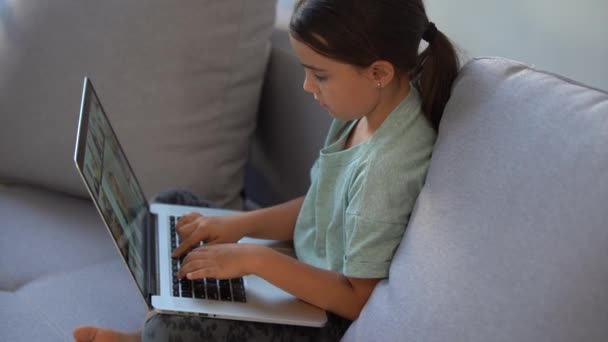 Aranyos gyermek használja laptop oktatás, online tanulmány. A lánynak házi feladata van otthon.. — Stock videók
