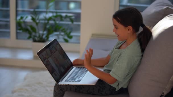 可爱的孩子用笔记本电脑接受教育，在线学习。女孩在家里做作业. — 图库视频影像