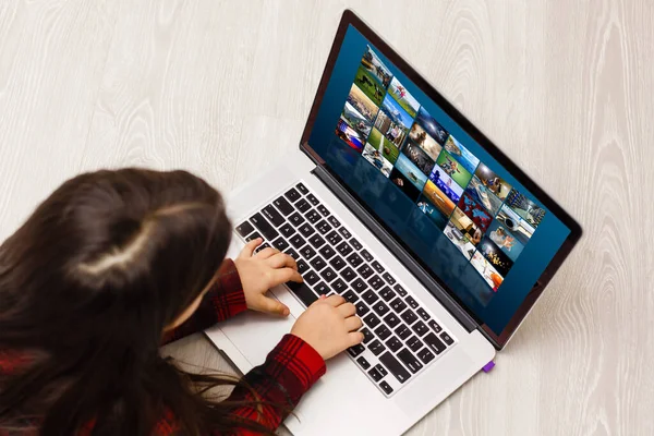 Casa, lazer, tecnologia e conceito de internet - pequena menina estudante com computador portátil em casa — Fotografia de Stock