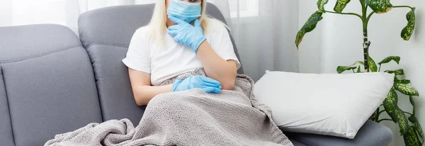 Mulher doente coberto com um cobertor deitado na cama com febre alta e uma gripe, descansando. Bule, comprimidos e limão na mesa — Fotografia de Stock