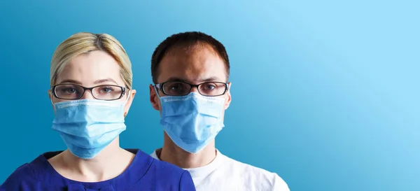 Mann und Frau mit Gesichtsmasken blicken in die Kamera, Coronavirus-Konzept. — Stockfoto
