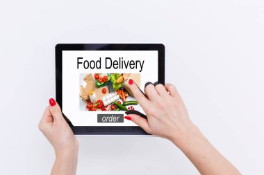Akıllı telefondan pizza sipariş eden bir kız. Masası, kahvesi ve bitkisi arka planda.