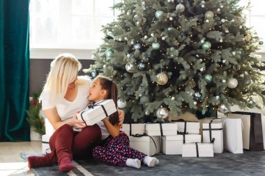 Anne ve kızının hediye kutularıyla çekilmiş resmi, Noel.