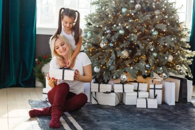 Anne ve kızının hediye kutularıyla çekilmiş resmi, Noel.