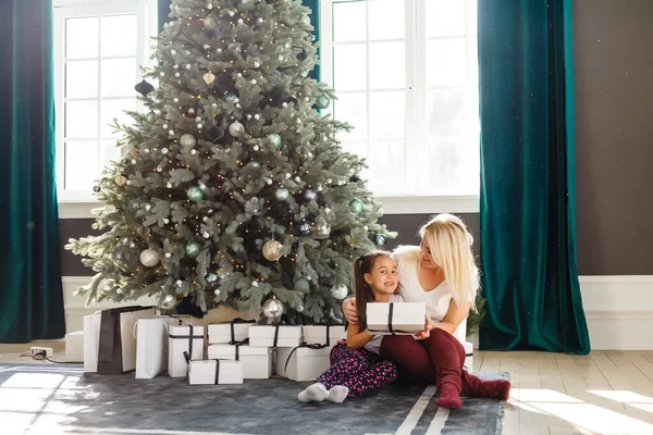 Anne ve kızının hediye kutularıyla çekilmiş resmi, Noel.