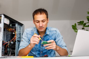 Bilgisayar mühendisi bozuk konsol üzerinde çalışıyor