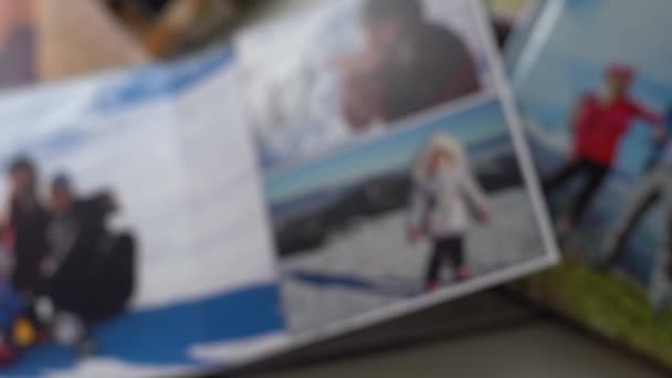 Close up. a woman flips through a photo book from a family photo shoot in the garden. beautiful and convenient storage of photos. memory of an important period. — Stock Video