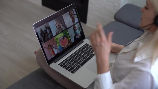 Online Group Video Call Συνέδριο της Ομάδας Εργασίας από το Υπουργείο Εσωτερικών. Η Γυναίκα στα Ακουστικά συνομιλεί με ανθρώπους στο Video Chat χρησιμοποιώντας Laptop. Αυτοαπομόνωση στην πανδημία COVID-19. 4K Top View Μεσαία βολή τροχιάς — Αρχείο Βίντεο