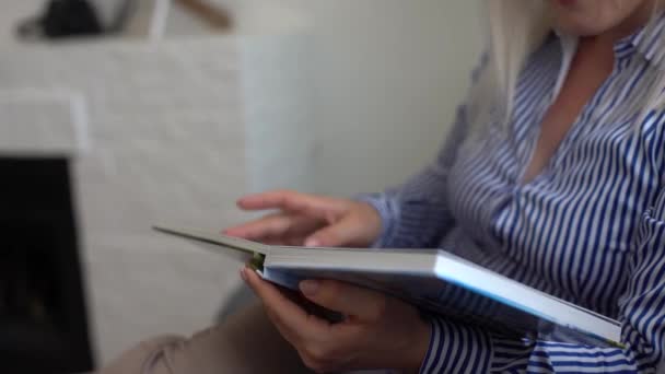 Giovane donna che guarda fotolibro a casa. Concetto di famiglia e tempo libero — Video Stock