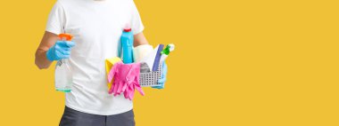 Adam apartman temizliği yapıyor. Enfeksiyon önleme ve salgının kontrolü. Koruyucu eldivenler ve maske. sarı arkaplan