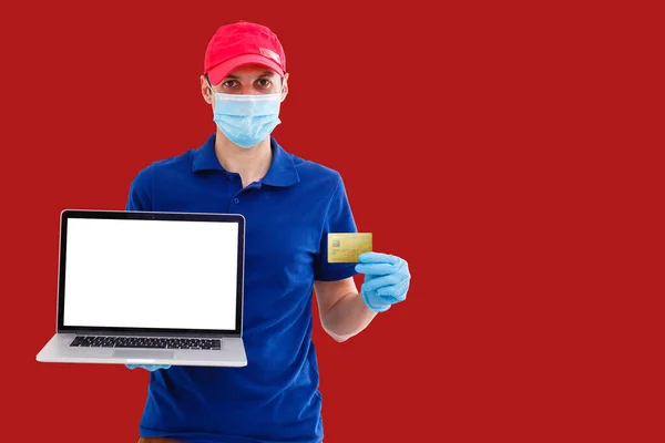 man orders online products buying online with a laptop and credit card, red background