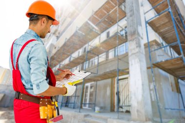 Gülümseyen İnşaat işçisi. Mimari arkaplan.