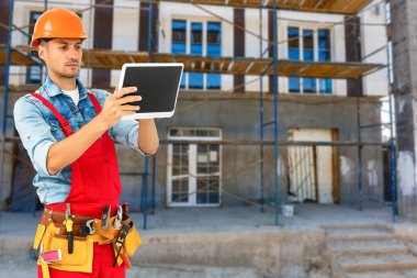 Gülümseyen İnşaat işçisi. Mimari arkaplan.