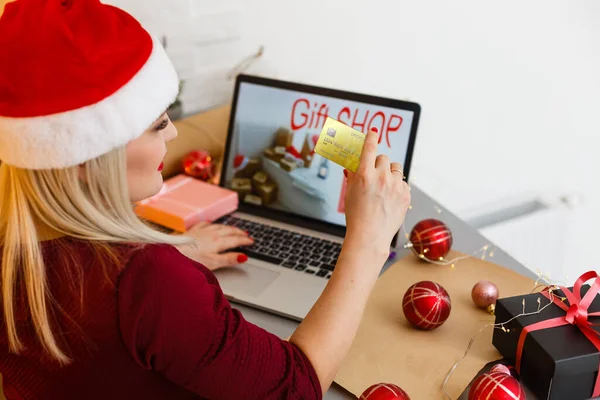 기사보기 온라인 크리스마스 쇼핑을 여성이 모자를 크리스마스 사항을 확인하며 자신의 — 스톡 사진