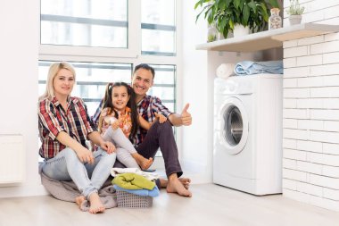Çamaşır yıkayan mutlu bir aile imajı.