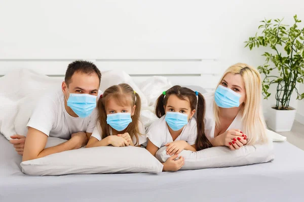 family in protective masks quarantined. Normal life with coronavirus. Lifestyle COVID-19. Quarantine virus protection christmas