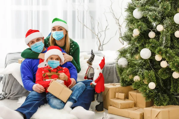 family in protective masks quarantined. Normal life with coronavirus. Lifestyle COVID-19. Quarantine virus protection christmas