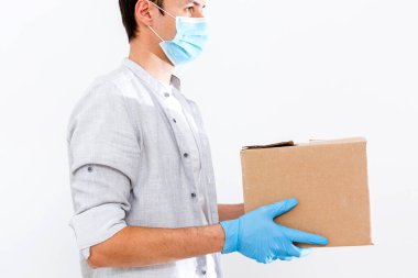 Karton kutuları tıbbi lastik eldiven ve maskeyle taşıyan teslimatçı. kopyalama alanı. Hızlı ve ücretsiz teslimat. İnternetten alışveriş ve ekspres teslimat. Karantina