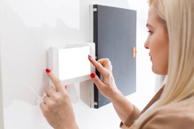 İçerideki kadın güvenlik telefonuna cevap veriyor.