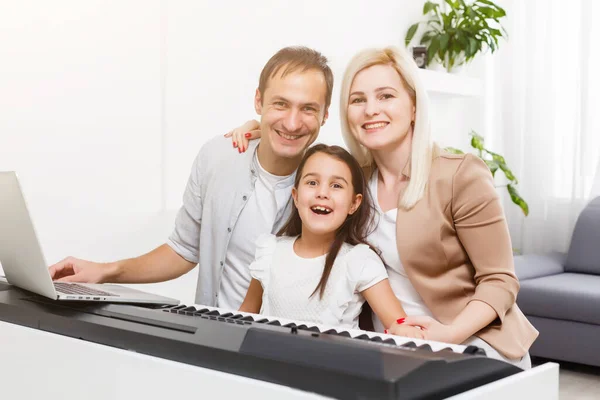 family plays the digital piano at home, learning online, family rest during quarantine, self-isolation, online education concept. support for loved ones concept