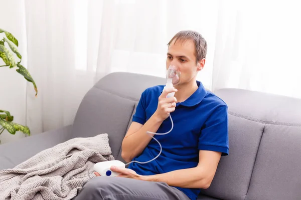 Portrait Of Young Man Inhaling Through Inhaler Mask