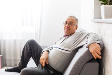 Yaşlılar yurdunda üzgün bir şekilde yatmakta olan Kafkas erkek hasta, sosyal mesafeler ve Coronavirus Covid19 karantinasında kendini tecrit etme