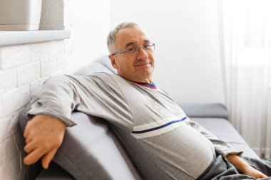 Yaşlılar yurdunda üzgün bir şekilde yatmakta olan Kafkas erkek hasta, sosyal mesafeler ve Coronavirus Covid19 karantinasında kendini tecrit etme