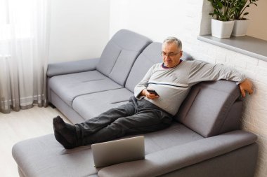 Yaşlı adam COVID-19 Coronavirüs salgını sırasında evde kalıyor. Sunbae, Coronavirus için endişeleniyor ve evden çalışıyor. Sosyal uzaklık ve karantina kavramı.