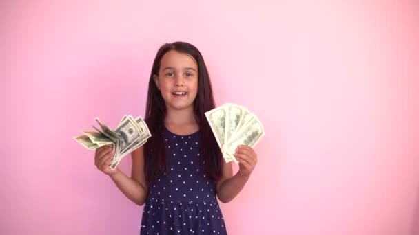 Little caucasian child girl receives money income in banknotes dollar cash. Happy kid having fun, smiling, looking at camera. — Stock Video