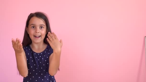 Egy kislány, aki a falon mutatja az írást. — Stock videók