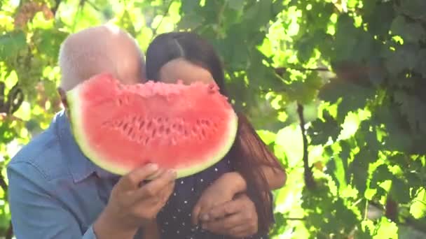 Kleines Mädchen und Großvater mit Wassermelone lächeln und essen — Stockvideo