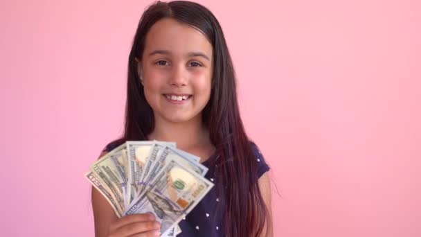 Маленькая кавказская девочка получает денежный доход в банкнотах наличными. Счастливый ребенок веселится, улыбается, смотрит в камеру. — стоковое видео