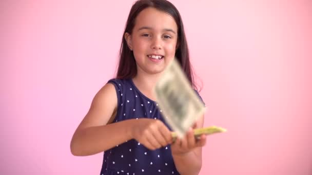 Pequena menina caucasiana recebe rendimentos monetários em notas de dólar em dinheiro. Criança feliz se divertindo, sorrindo, olhando para a câmera. — Vídeo de Stock