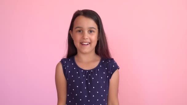 Alegría infantil emocionada felicidad, emocionalmente regocijo en el éxito de la victoria, ganador. Pequeña niña divertida sobre fondo rosa — Vídeo de stock