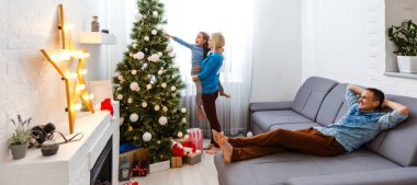 Mutlu genç aile Noel 'i evde kutluyor.