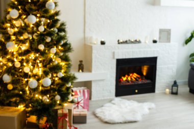 Noel sahnesinde ağaç hediyeleri ve arka planda ateş