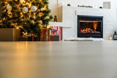 Noel sahnesinde ağaç hediyeleri ve arka planda ateş