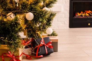 Altında hediyeler olan Noel ağacıyla süslenmiş güzel bir holdiay odası.