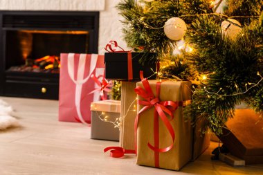 Altında hediyeler olan Noel ağacıyla süslenmiş güzel bir holdiay odası.