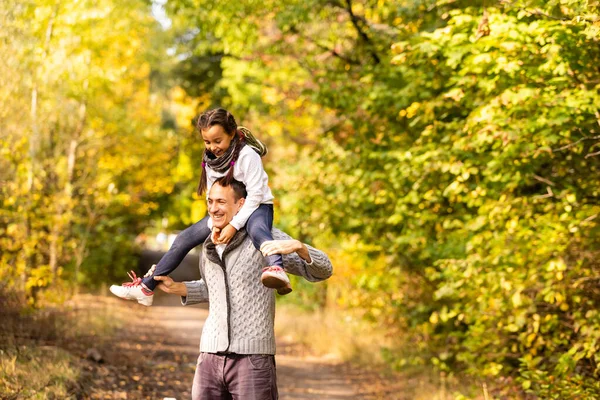 公園の紅葉の散歩に幸せな家族の父と子供の娘 — ストック写真
