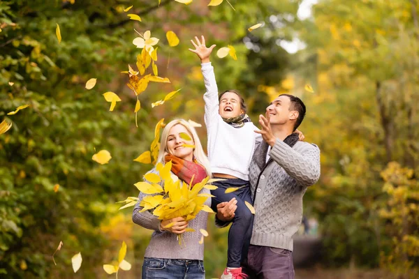 紅葉を背景に 秋の公園でアウトドアを楽しんでいる幸せな家族 — ストック写真