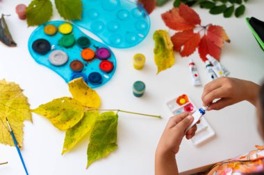 Düşen yapraklarla resim çizen kız..