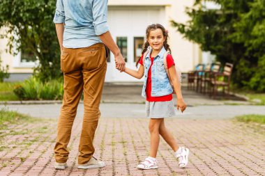 Okuldaki ilk günüm. Babam ilkokulda küçük bir kızı yönetiyor.