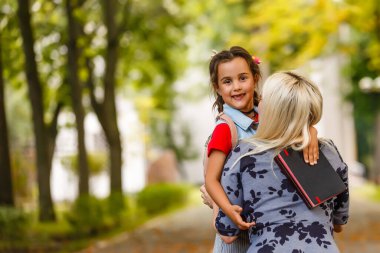 Genç anne kızını okula götürüyor..