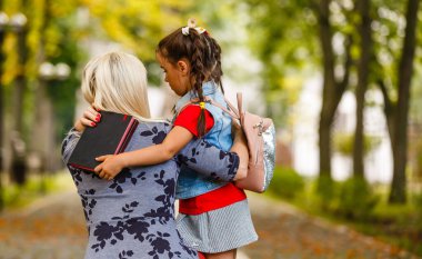 Genç anne kızını okula götürüyor..