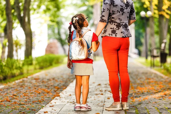 Okuldaki ilk günüm. Annem ilkokulda küçük bir kızı yönetiyor.