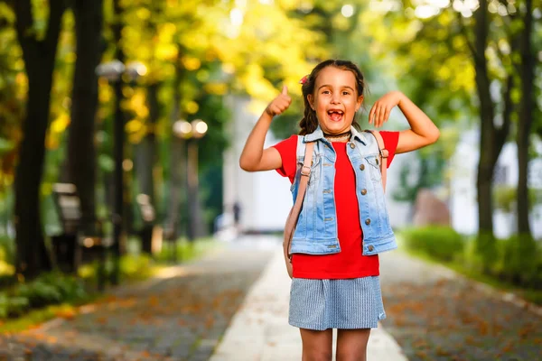 Sabahları küçük bir kız sıcak güneşin altında sırt çantasıyla okula gidiyor. Eğitim kavramı.
