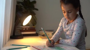 Akıllı ilkokul çocuğu matematik ödevi yapmayı öğreniyor. Evde oturuyor, sevimli, küçük bir anaokulu çocuğu tek başına çalışıyor. Notlar alıyor, ilköğretim konsepti geliştiriyor.