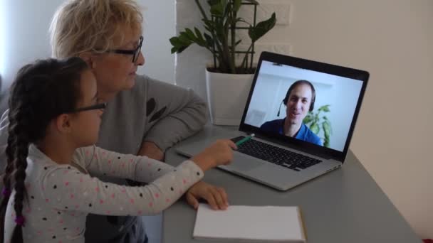 Mooi basisschoolmeisje afstandsonderwijs thuis. Gericht schattig kind luisteren audio les studeren aan tafel, huiswerk maken. Kinderen onderwijs op afstand over quarantaine concept. — Stockvideo