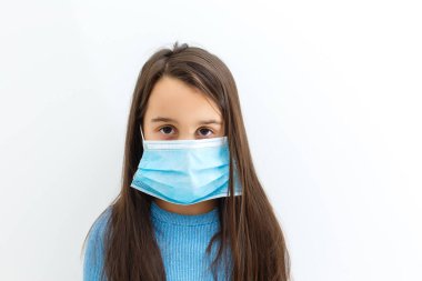 PM2.5 ve Covid-19 virüslerine karşı korunmak için maskeli küçük bir kız. Corona virüsü salgını. Bakterilere karşı korunmak için tıbbi maske.